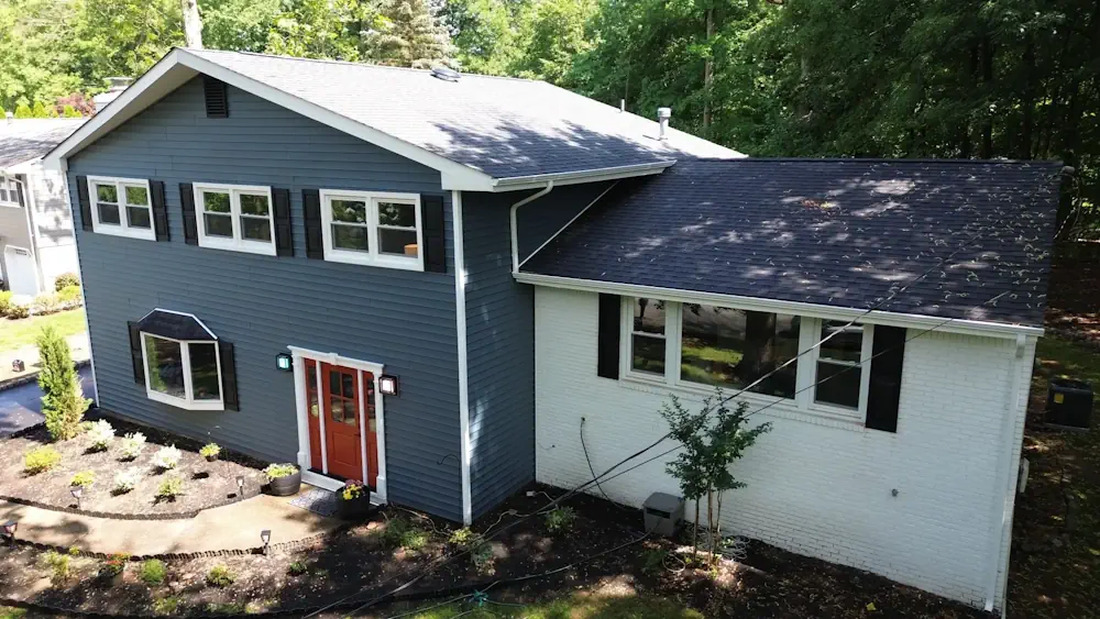 Blue siding installation with white brick and red door by Double D Construction