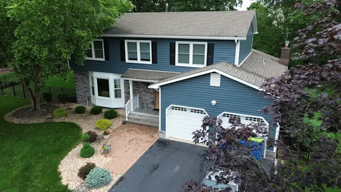 Blue siding installation with stone facade showcasing complete exterior transformation by Double D Construction